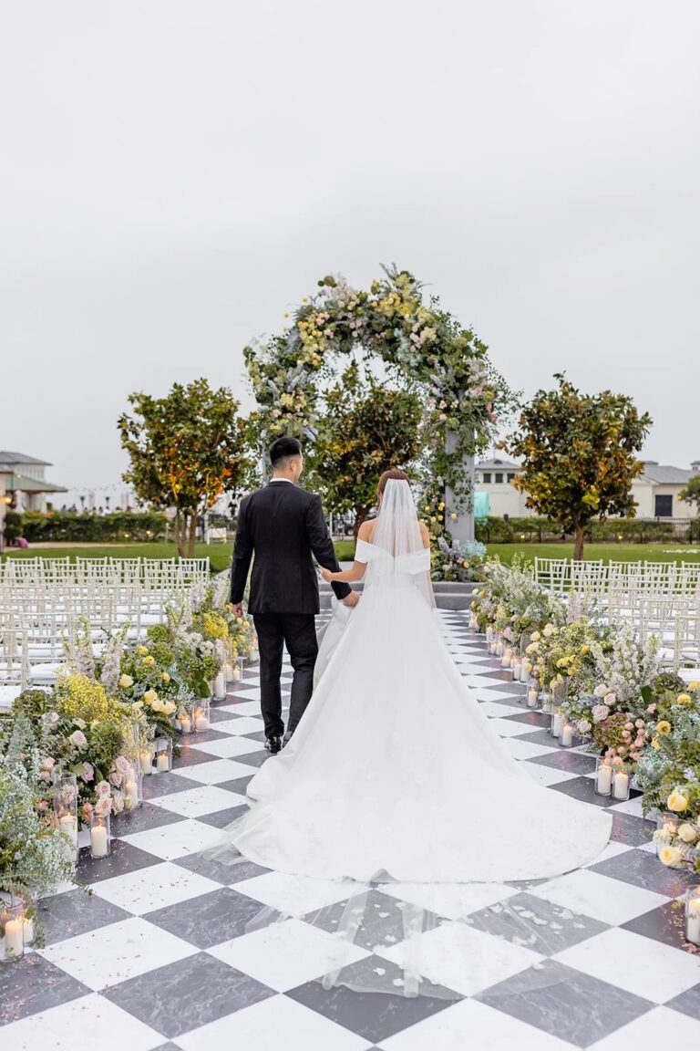 Checkered aisle leading to a floral arch with citrus trees, About Details Details