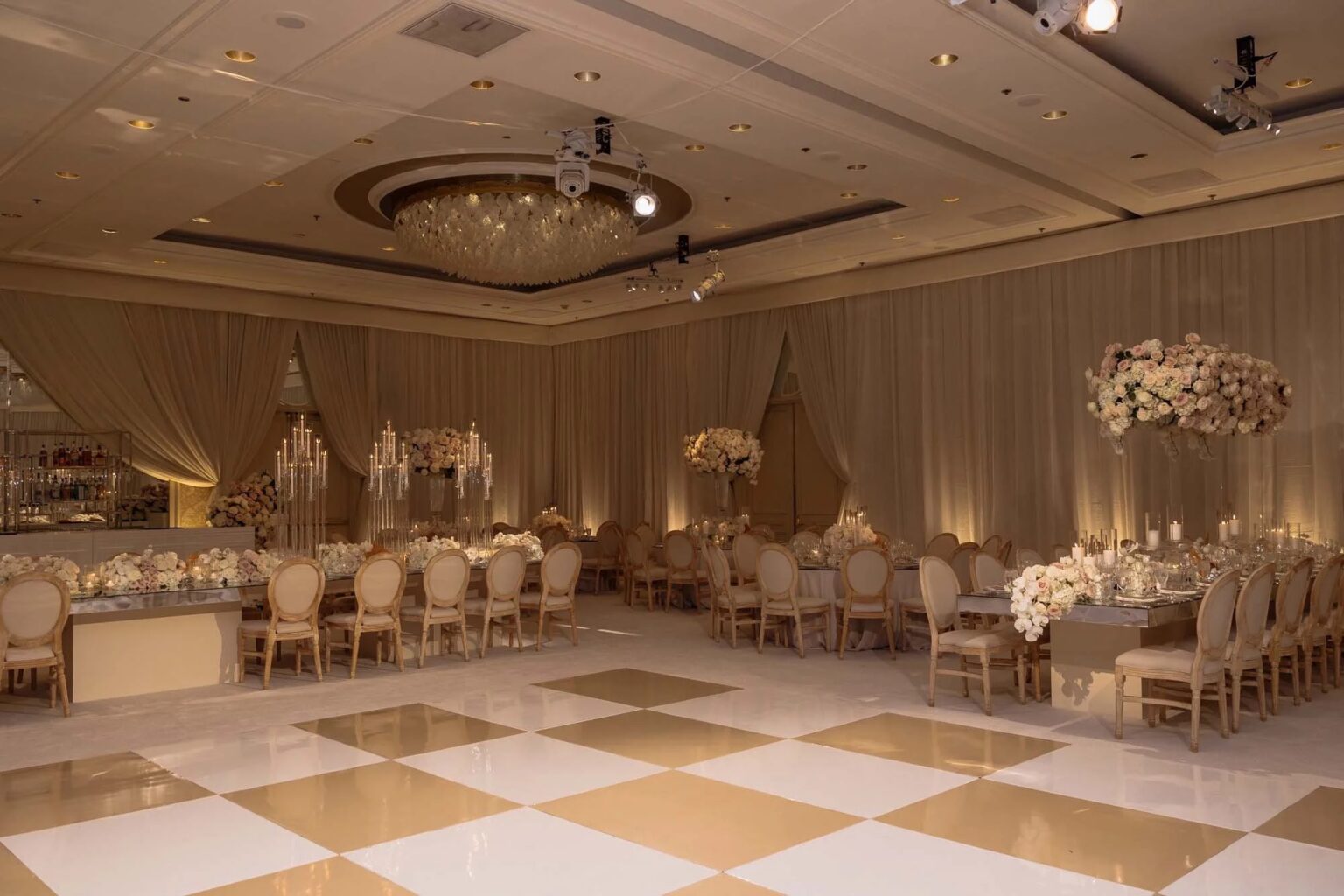 Hotel ballroom with gold chairs, chandeliers and tall floral centrepieces, About Details Details