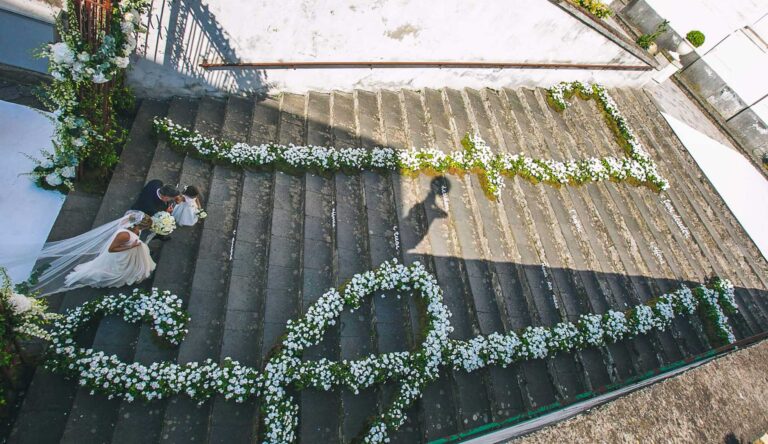 Church steps in the Amalfi Coast lined with floral garlands, seen from above, Alba Greco