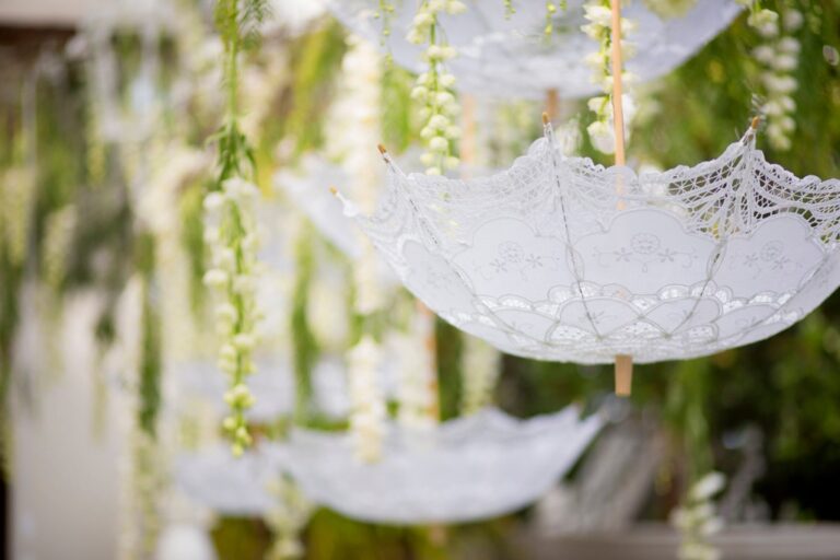 Lace umbrellas hung among greenery for a green and white wedding, Alba Greco