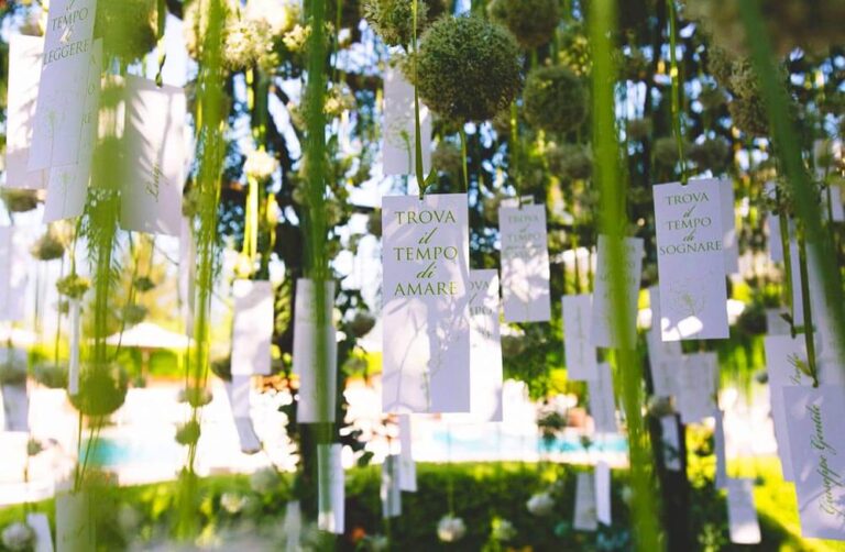 Place cards hung among green stems at a lotus-theme wedding, Alba Greco