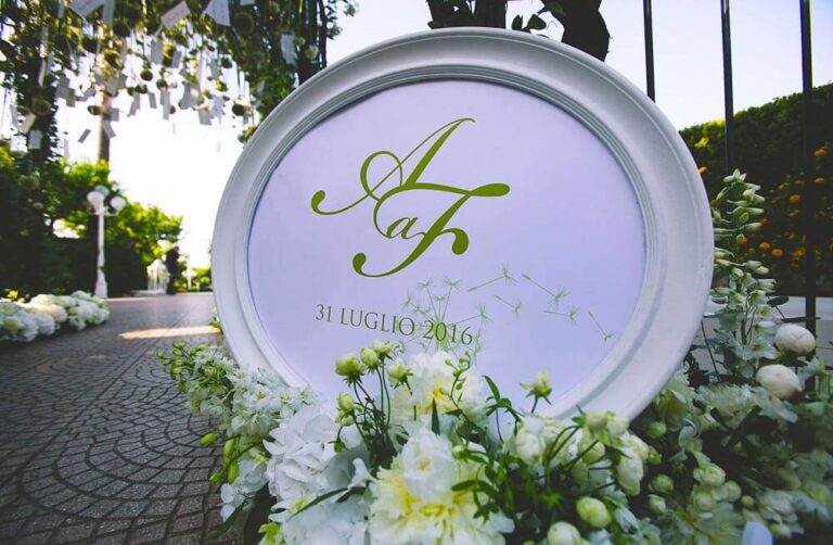 Monogram sign with white flowers on a garden path at a lotus-theme wedding, Alba Greco