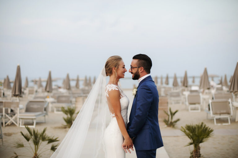Couple with a long veil on a seaside terrace of sunloungers, Alessandro Mari Photography