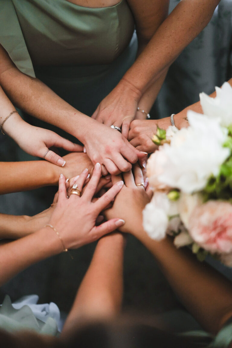 Bridesmaids joining hands over the bouquets, Alessandro Mari Photography