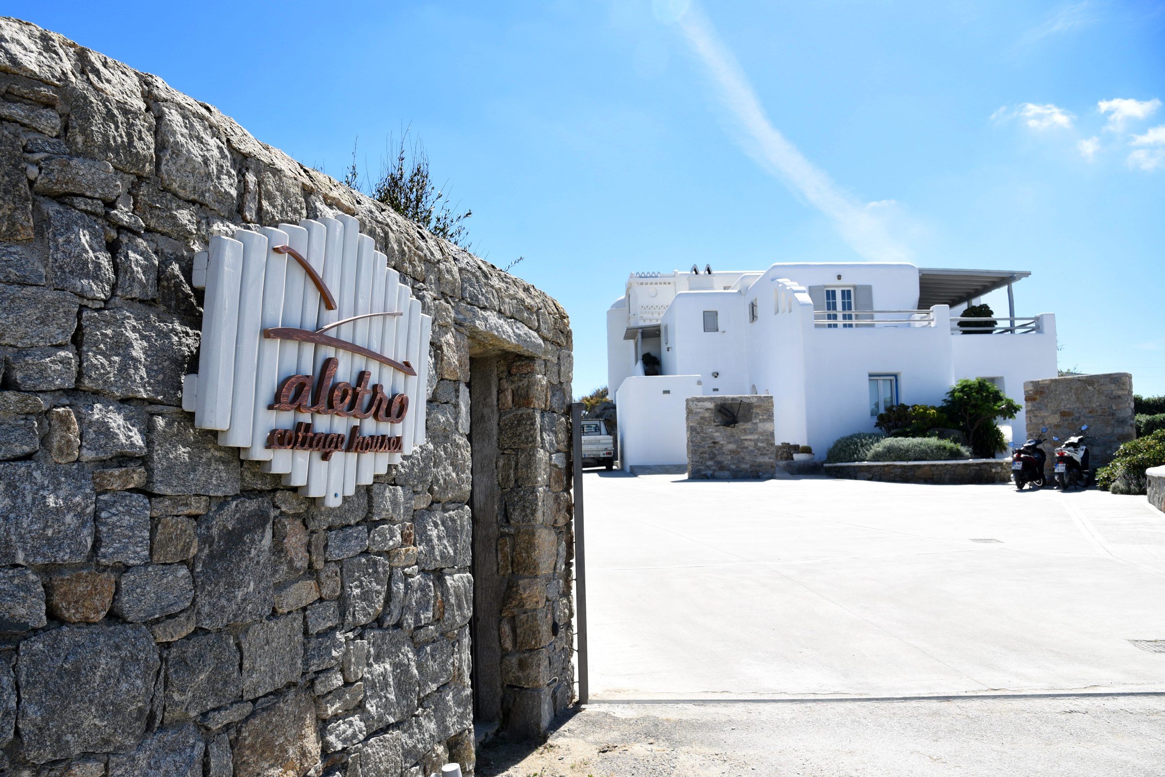 The stone entrance wall and sign at Aletro Cottage Houses