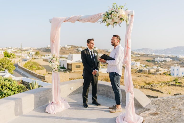 A ceremony under a pink draped arch