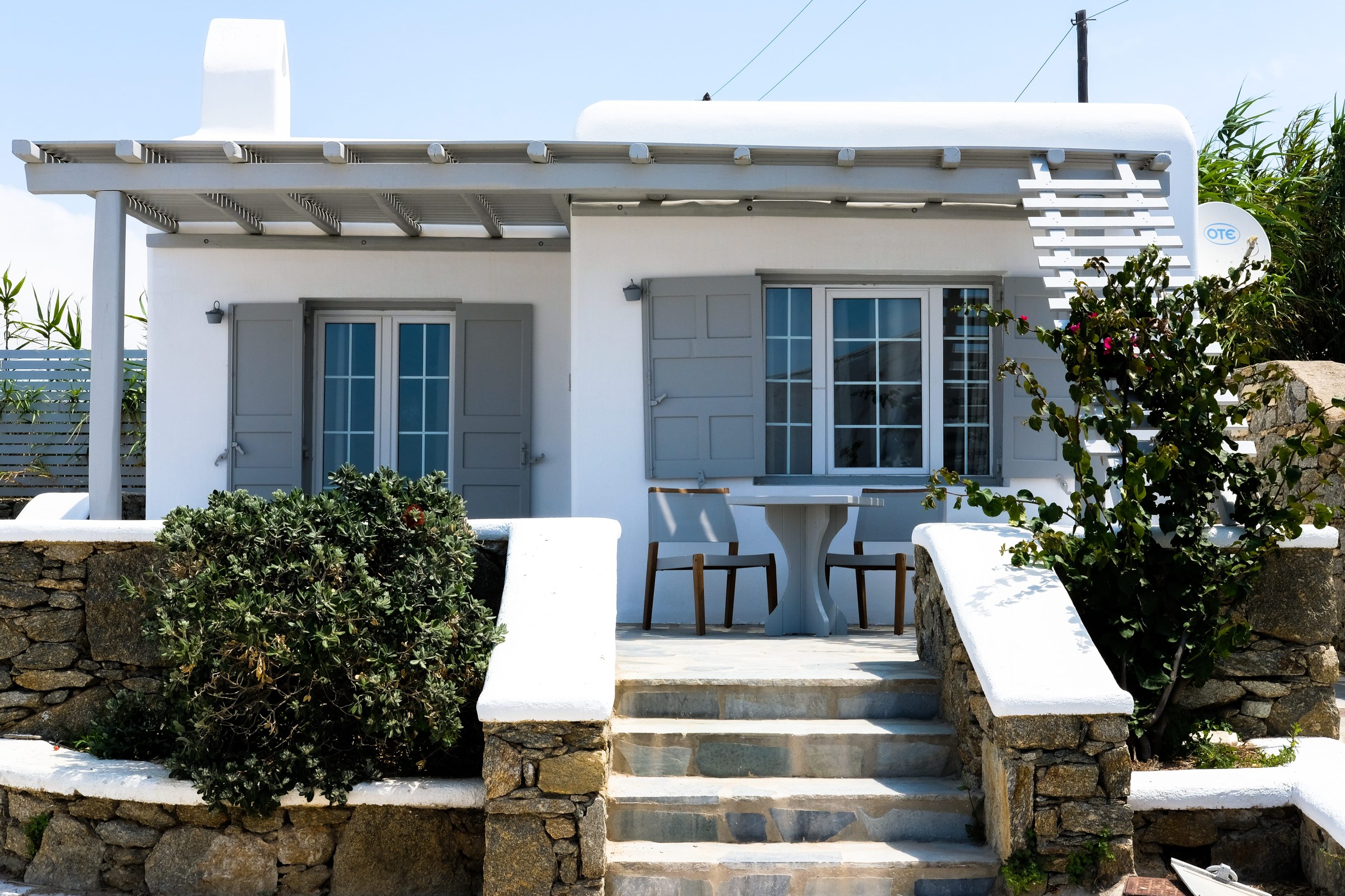 A whitewashed cottage with a stone-stepped terrace