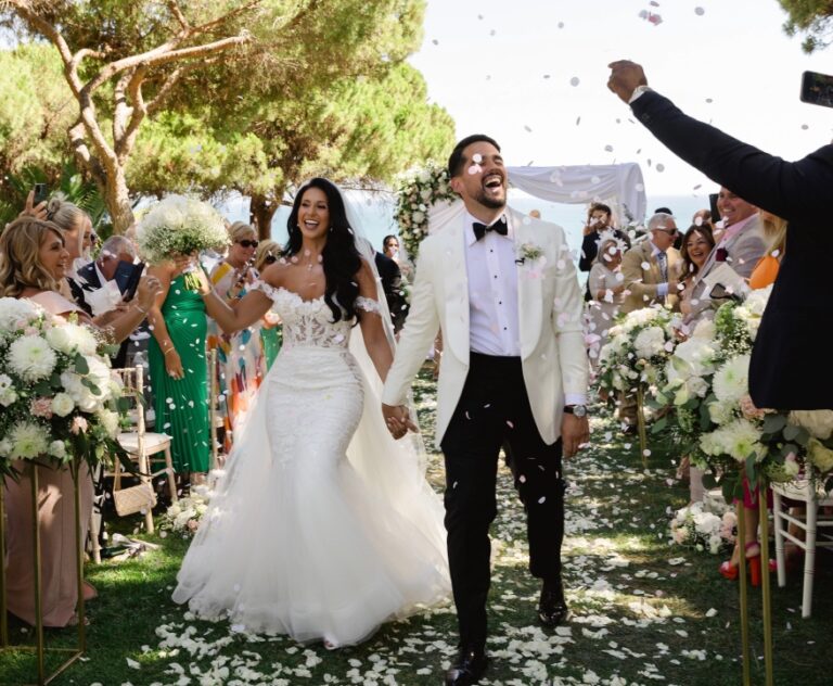 Couple walking back down a petal-strewn aisle among guests, Algarve Wedding Planners