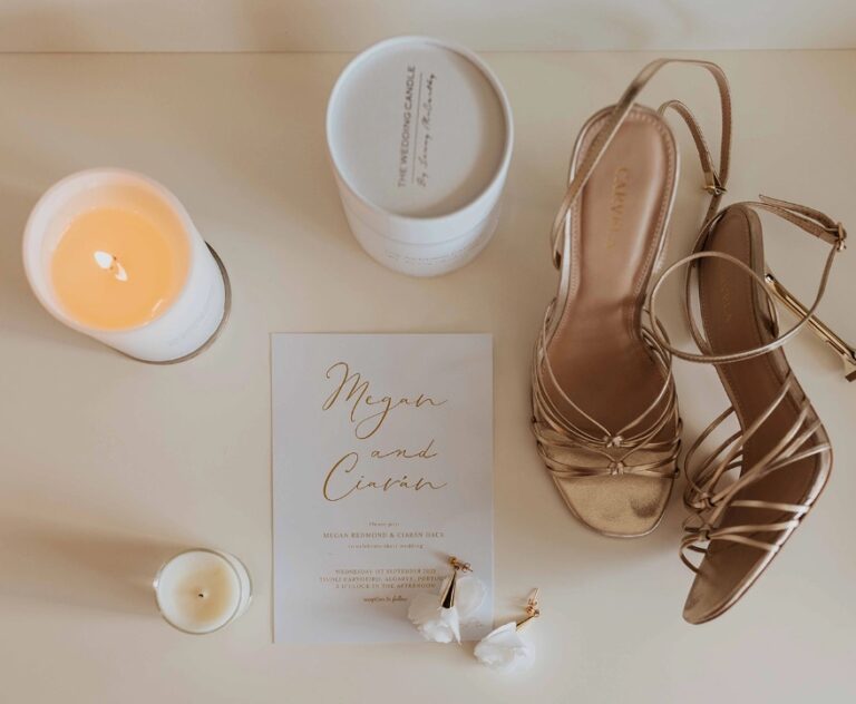 Invitation, candle and gold sandals laid out together, Algarve Wedding Planners