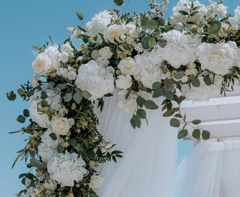 White rose and eucalyptus arch against a blue sky, Algarve Wedding Planners