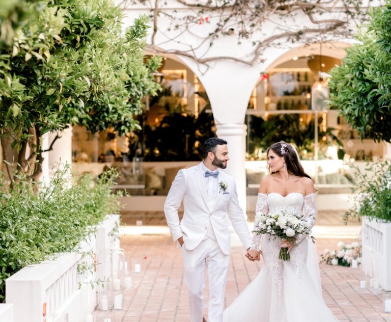 Couple walking through a whitewashed garden at dusk, Algarve Wedding Planners
