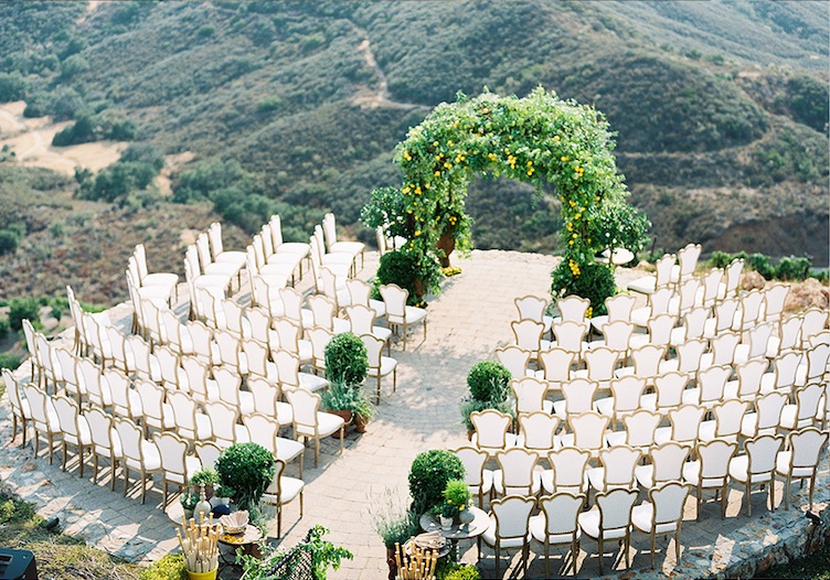 Hillside ceremony seating with a greenery arch, seen from above, Aliana Events