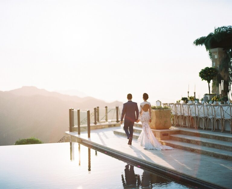 A couple walking beside an infinity pool at sunset above the hills, Aliana Events