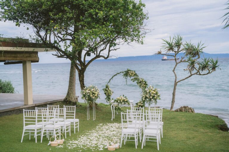 A floral ceremony arch on the lawn beside the sea, Alila Manggis