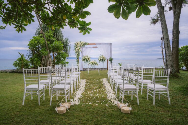 Ceremony chairs and a flower arch on the oceanfront lawn, Alila Manggis