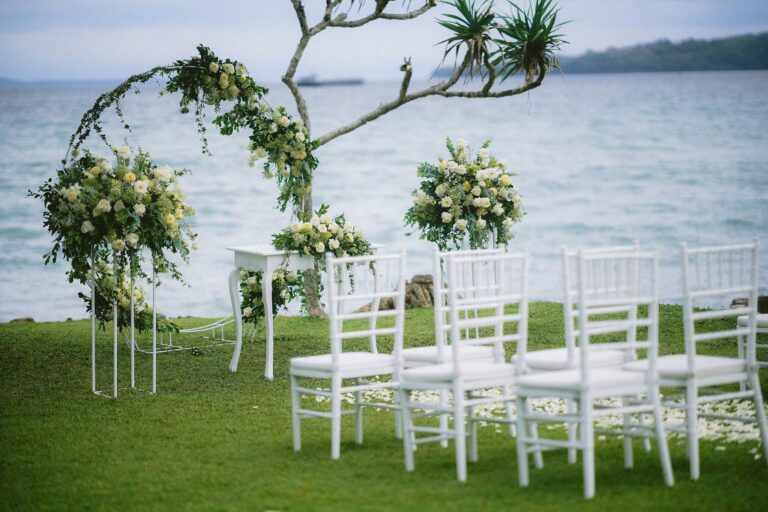A circular floral arch and white chairs on the lawn, Alila Manggis