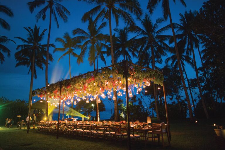A long dining table under lanterns in the Coconut Grove at night, Alila Manggis