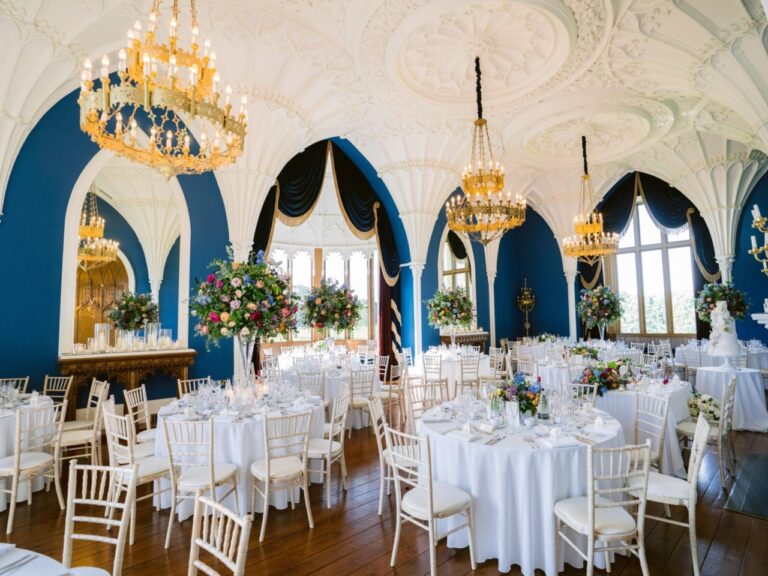 The vaulted Ballroom laid for the wedding breakfast, white linen beneath the blue Gothic arches, Allerton Castle