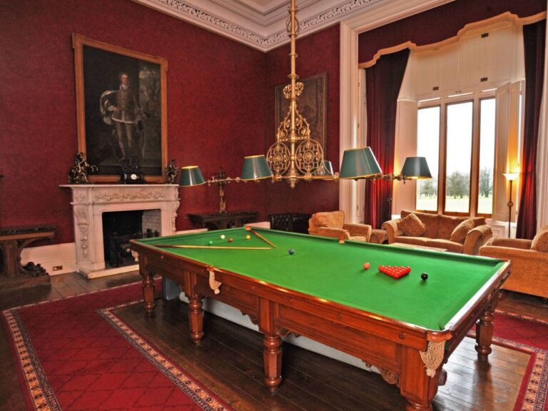 The Billiard Room, its snooker table beneath a chandelier and a portrait, Allerton Castle