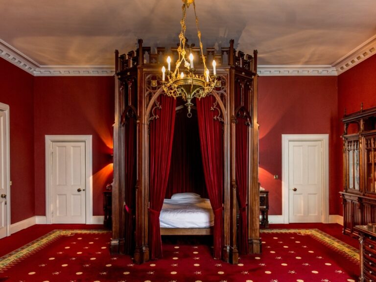 A red bedroom with a canopied four-poster and Gothic doors, Allerton Castle