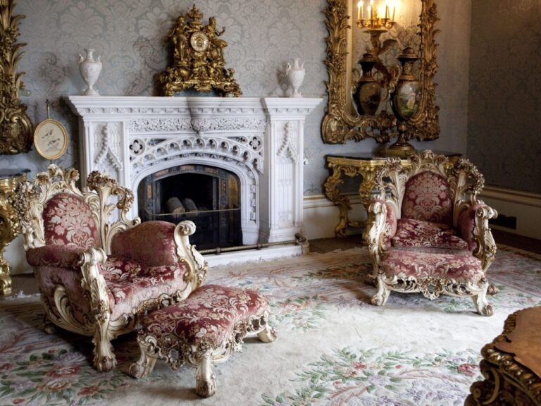 An ornate white marble fireplace framed by gilded armchairs, Allerton Castle