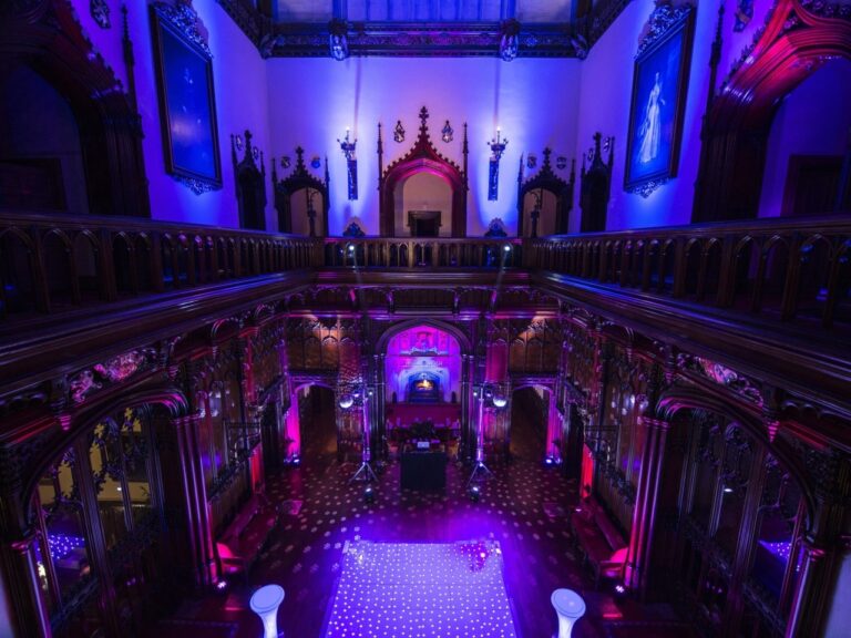 The Great Hall dressed for the evening party, the staircase washed in violet light, Allerton Castle