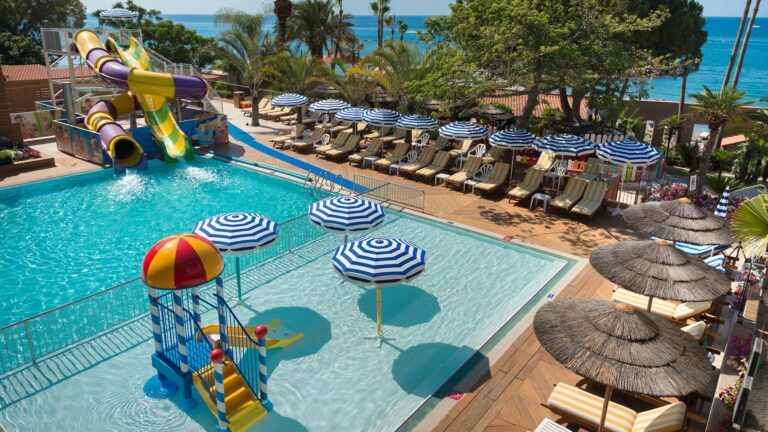 Pool with water slides and sun loungers, Amathus Beach Hotel