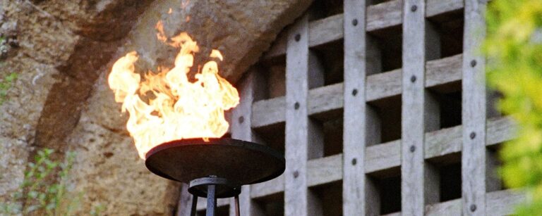 A flaming torch burning beside the castle's wooden portcullis, Amberley Castle