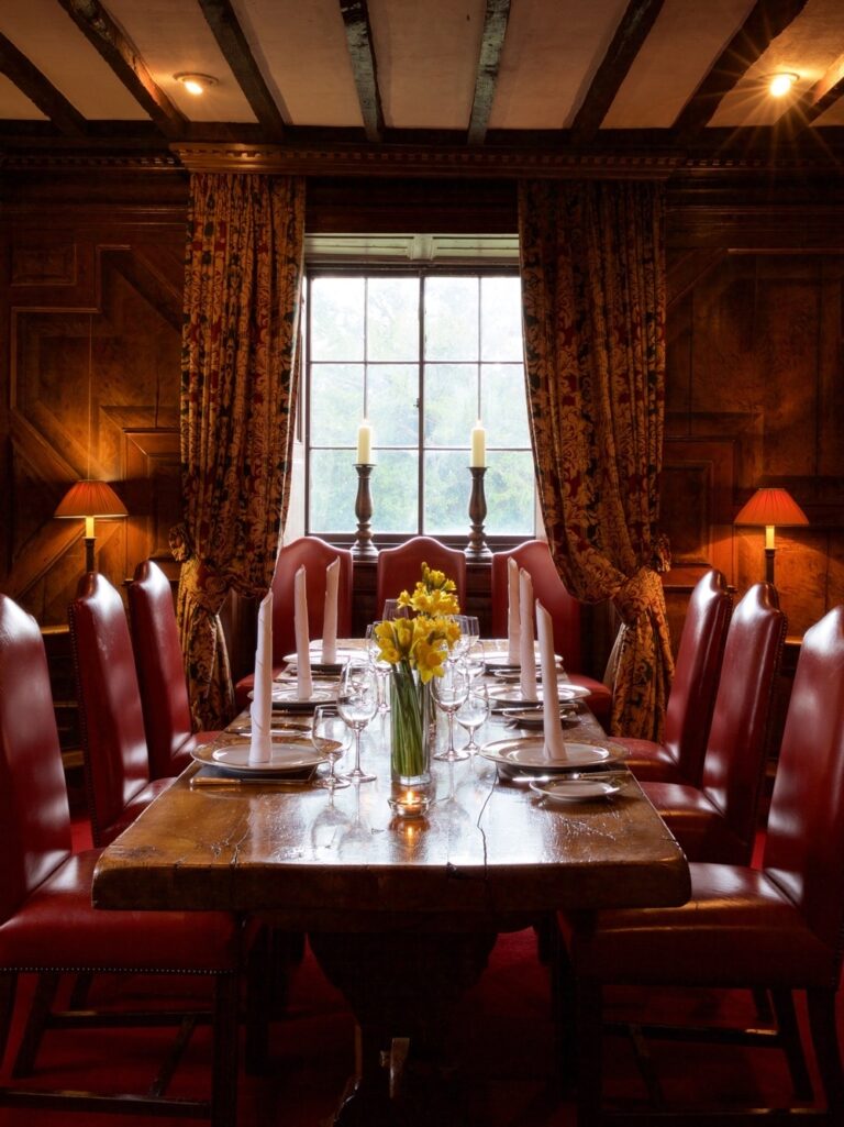 The King Charles I Room, an intimate wood-panelled dining room with a candlelit table, Amberley Castle