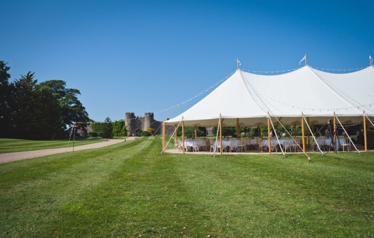 A sailcloth marquee on the lawn, the castle's towers rising beyond, Amberley Castle