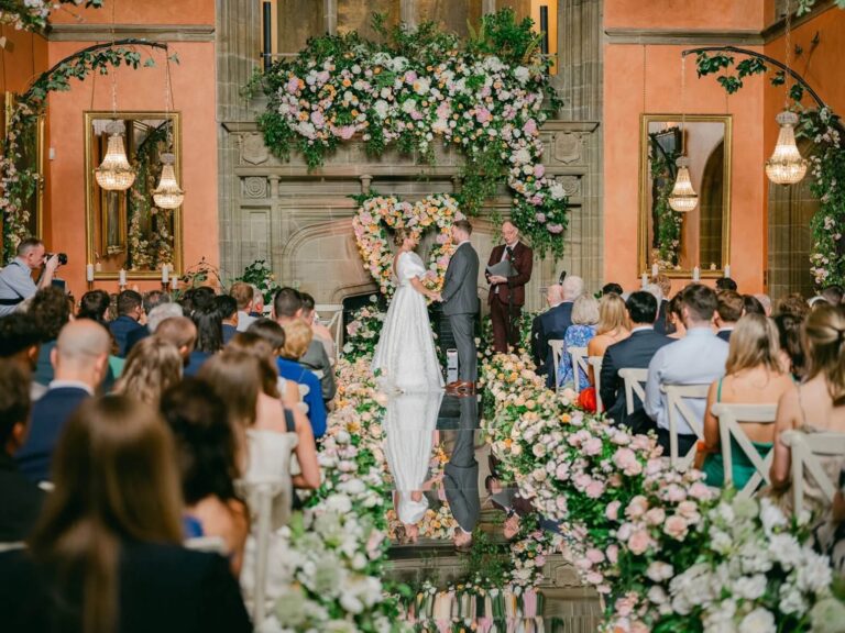 The couple at the altar beneath a floral heart, Cowdray House, Amie Bone