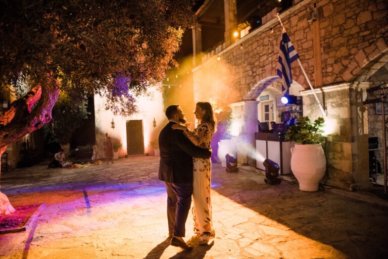 The first dance, under an olive tree, the Greek flag lit up behind, Andreas Markakis Photography
