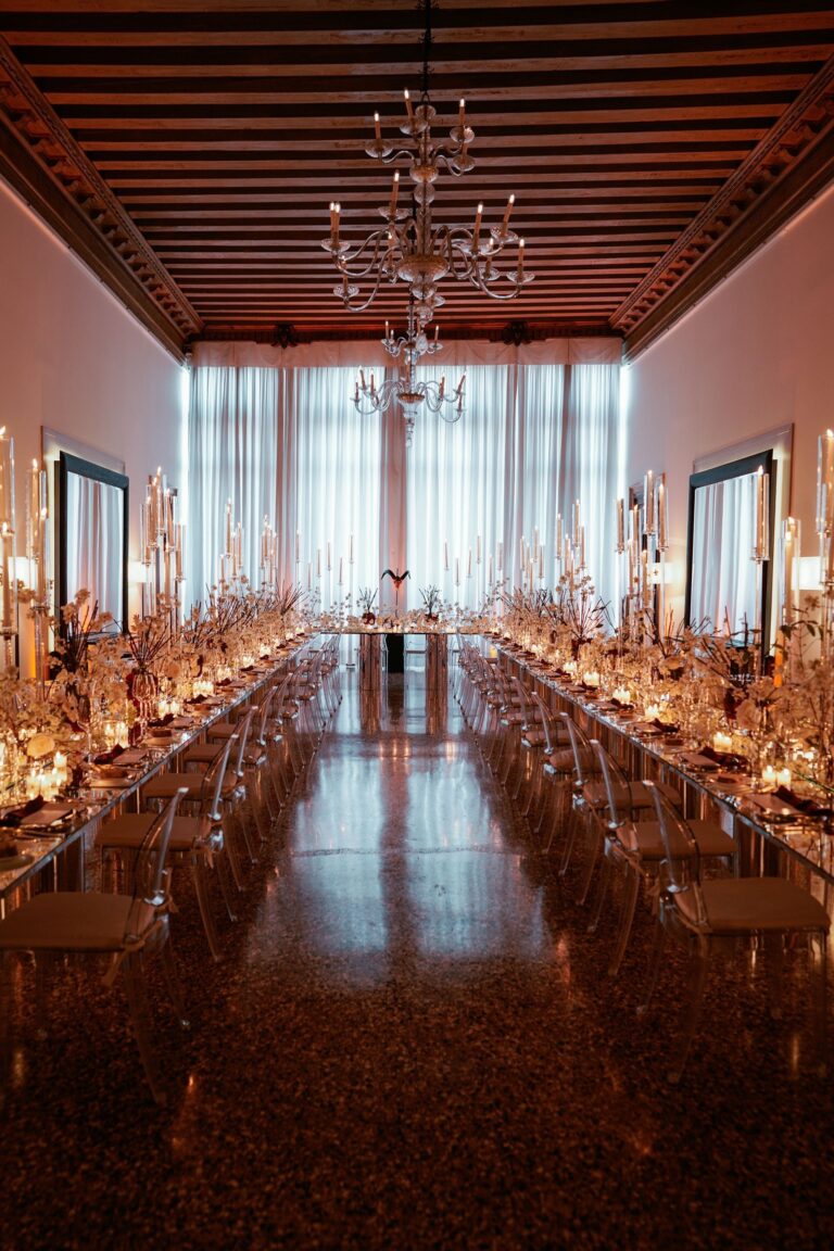 One long imperial table down a mirrored piano nobile under a chandelier, Angel Lion Weddings and Events