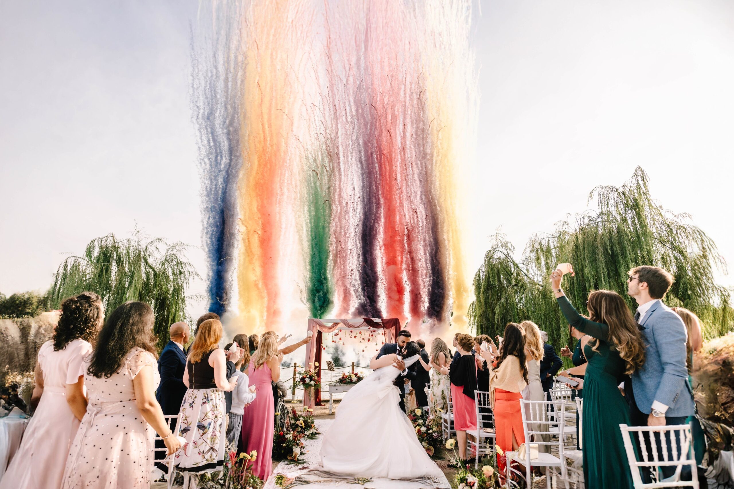 Rainbow colour smoke rising behind a lakeside wedding ceremony, Lake Garda, Angela Salzano