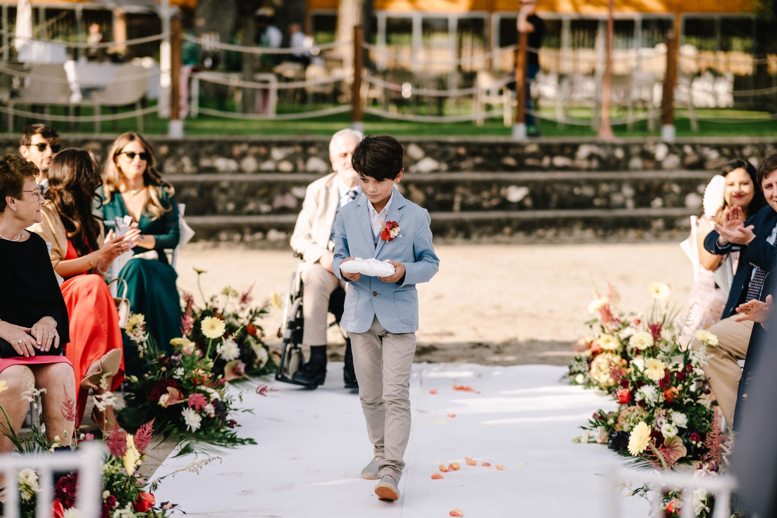 A young guest carrying the rings down the petal-strewn aisle, Angela Salzano