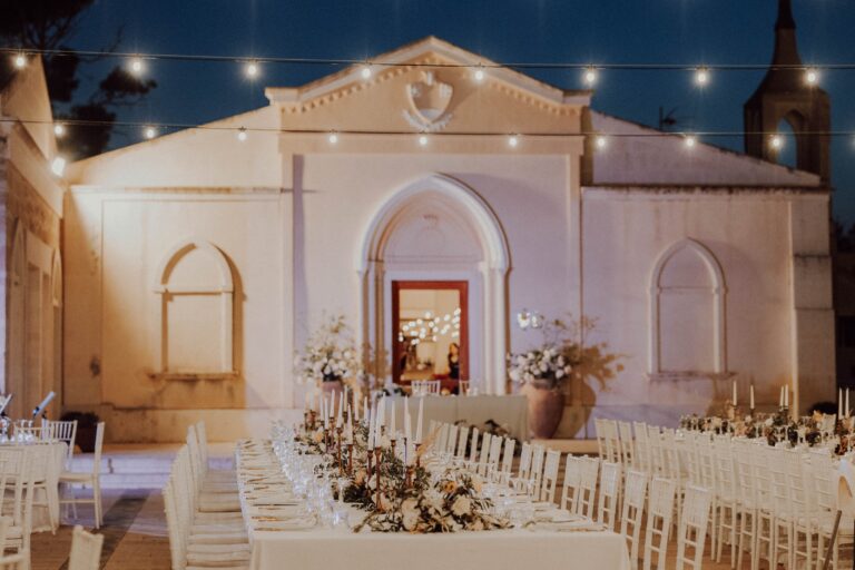 A chapel and long reception tables lit at night, Angela Salzano
