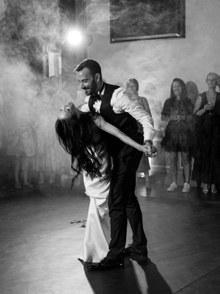 Black and white: the dip on the dance floor, smoke in the air, the guests watching, Anita Galafate