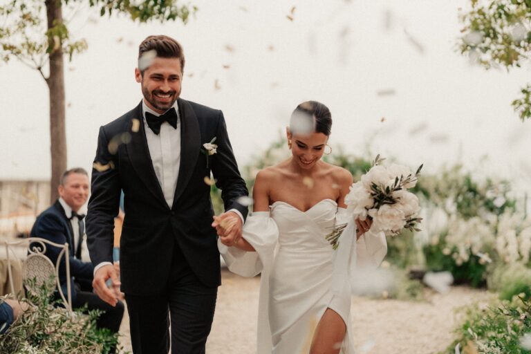 The couple walking out through a shower of confetti, the guests still seated, Anita Galafate