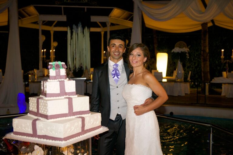 Carmen and Pasquale at their reception, wedding cake between them, Anna Rosa Makeup Italy