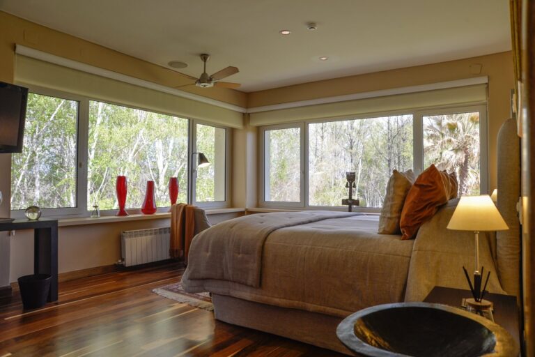Bedroom with a view of the garden through corner windows, Antucura Wine Estate