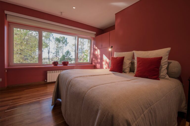 Red-walled bedroom with garden windows, Antucura Wine Estate