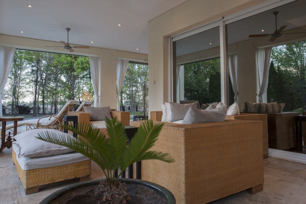 Sitting room with wicker seating and tall windows, Antucura Wine Estate