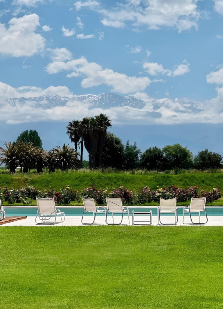 The pool and lawn below a blue sky, Antucura Wine Estate