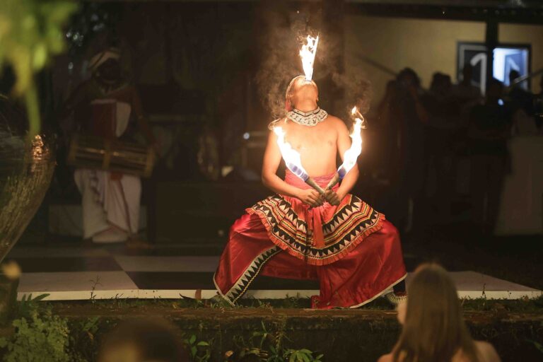 A performer in a red traditional costume with fire at a wedding evening, Anywhera Events The Destination Wedding Planner in Sri Lanka