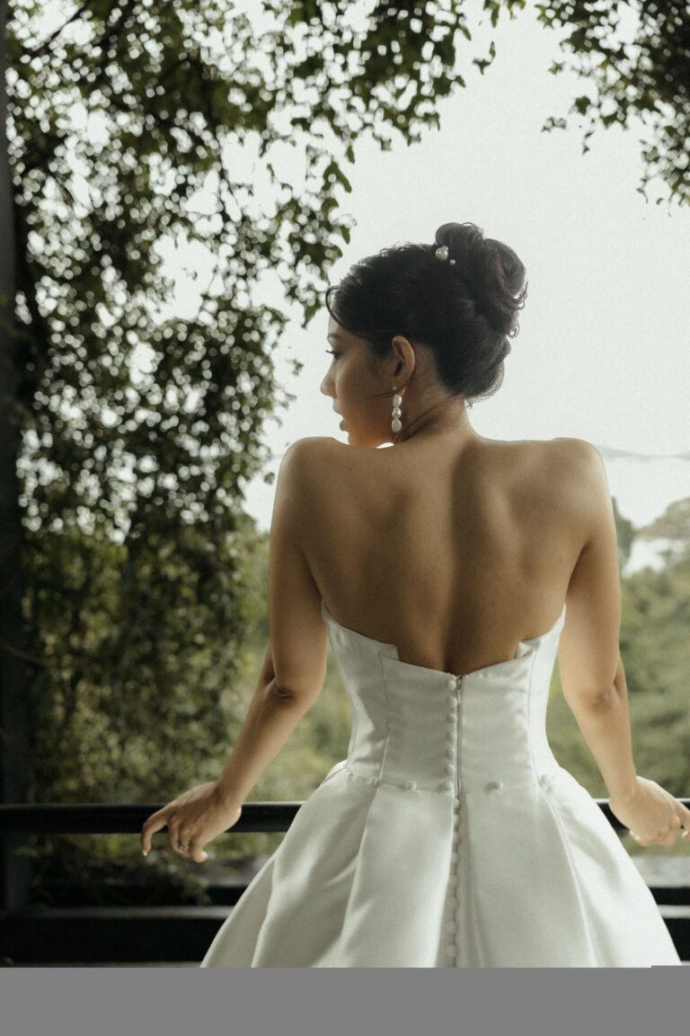 A bride seen from behind in a strapless gown with a buttoned back, looking out over greenery, Anywhera Events The Destination Wedding Planner in Sri Lanka