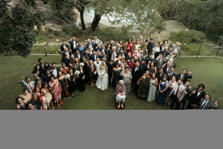An aerial view of the whole wedding party gathered and waving on a lawn, Anywhera Events The Destination Wedding Planner in Sri Lanka