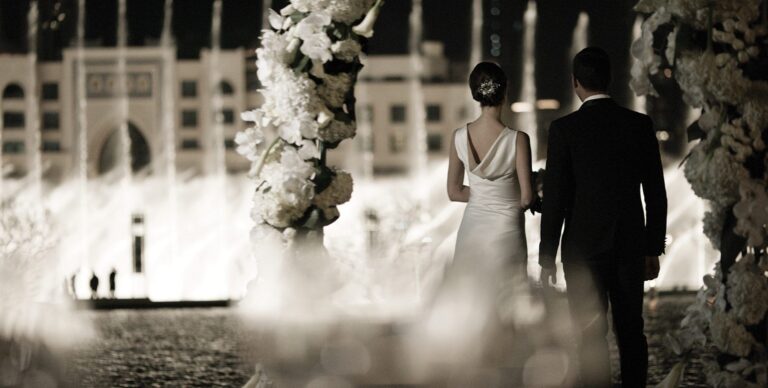 A couple beside a floral arch with the Dubai Fountain beyond, Armani Hotel Dubai