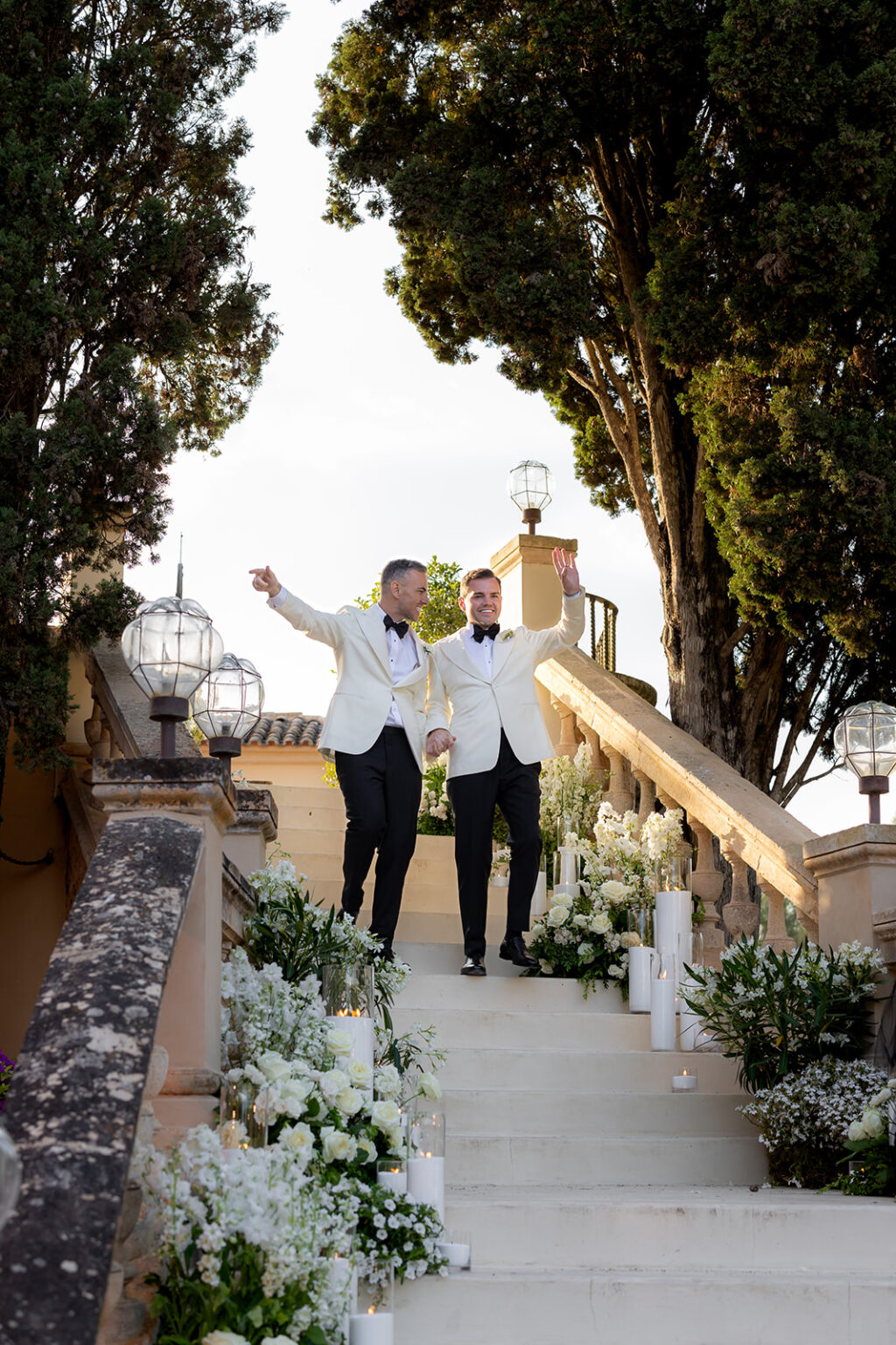 Two members of the band making an entrance down a flower-lined garden staircase