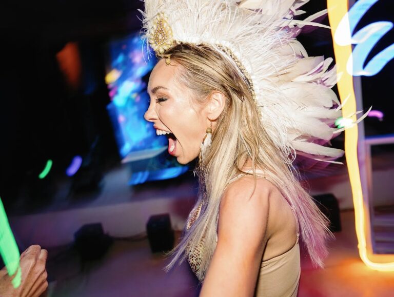 A singer in a feathered headdress performing on stage, Aston Band