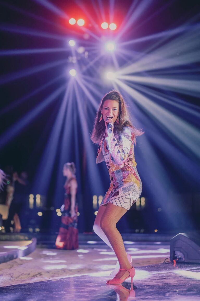 A singer performing on stage in a blaze of beam lights, Aston Band